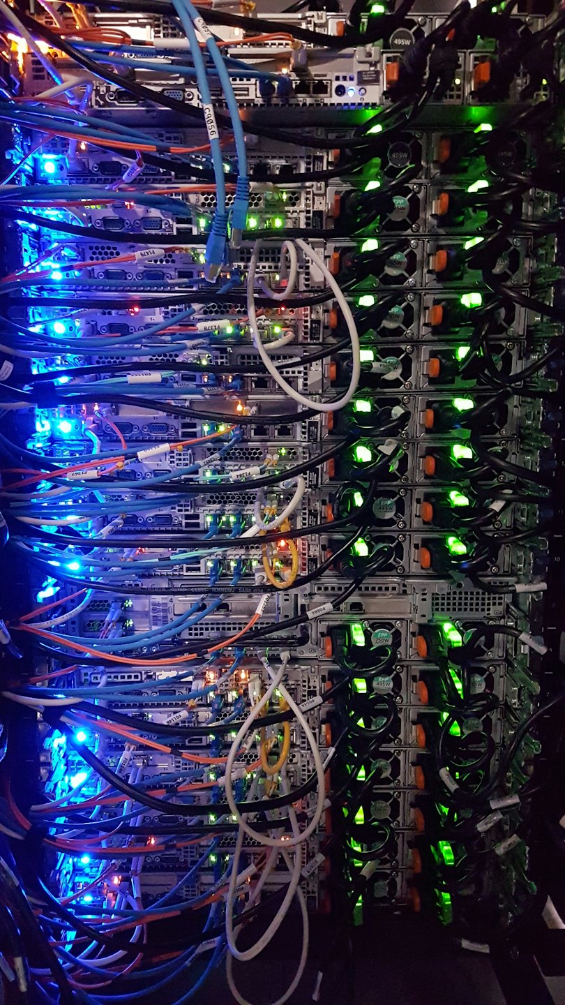 Server rack with many colorful cables and glowing lights.